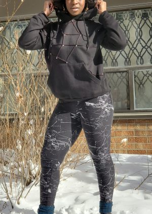 A woman in black jacket and gray pants standing on snow covered ground.