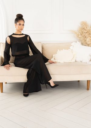 A woman in black dress sitting on a couch.