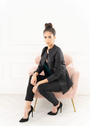 A woman sitting on top of a pink chair.