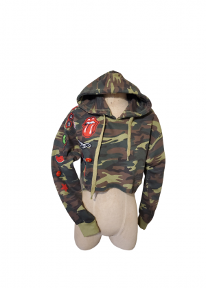 A mannequin wearing a camouflage jacket with rolling stones patches.