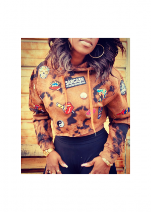 A woman wearing a brown jacket with patches on it.