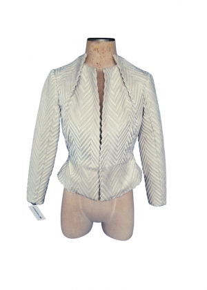 A white jacket is on display in front of a mannequin.
