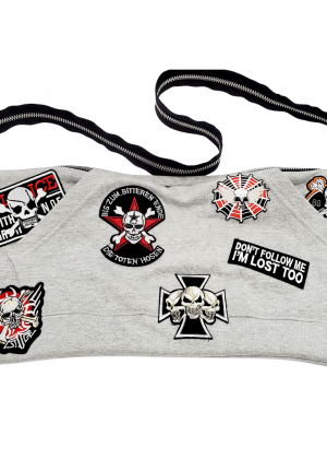 A gray purse with patches on it.
