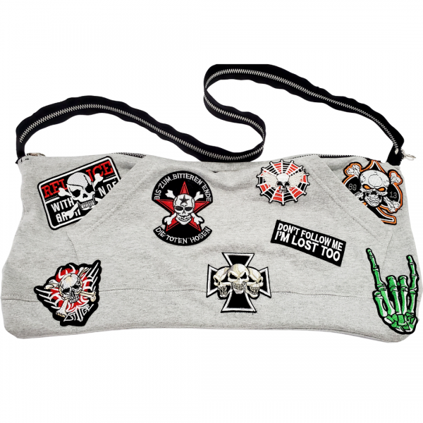 A gray purse with patches on it.