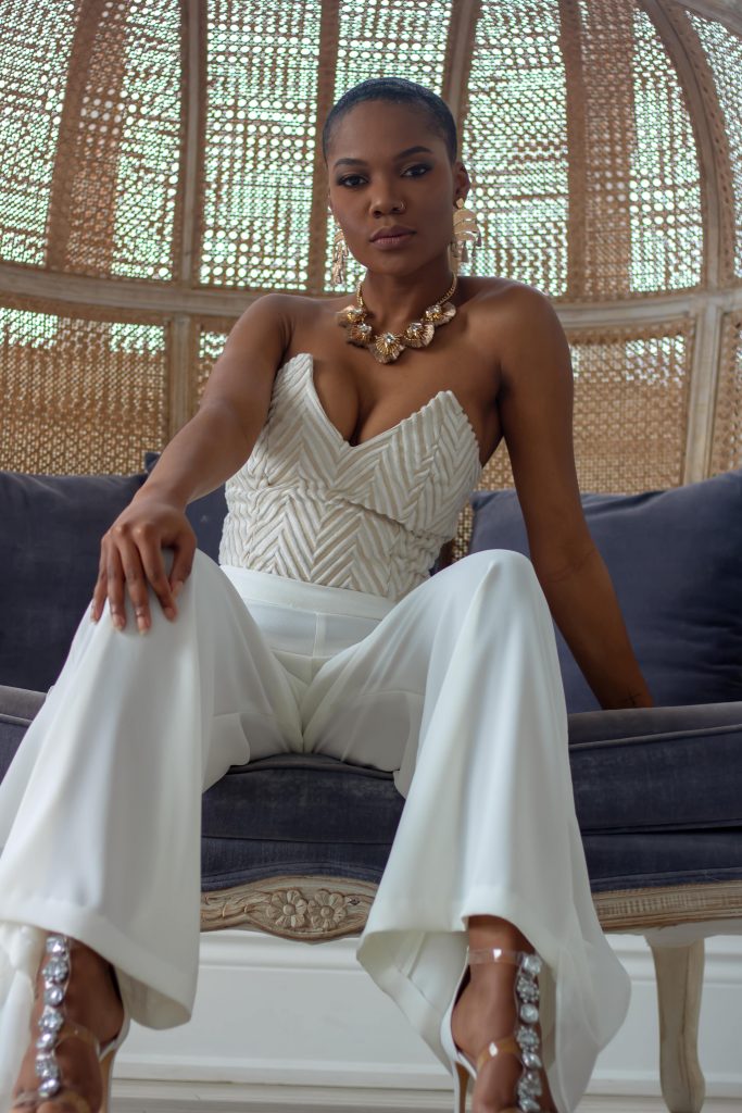 A woman in white pants and a strapless top.