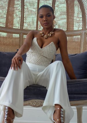 A woman in white pants and a strapless top.