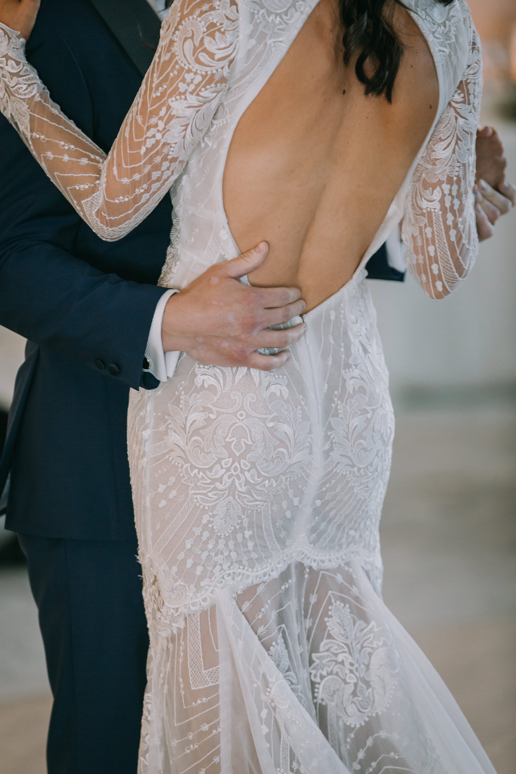A man and woman embracing in their wedding dress.