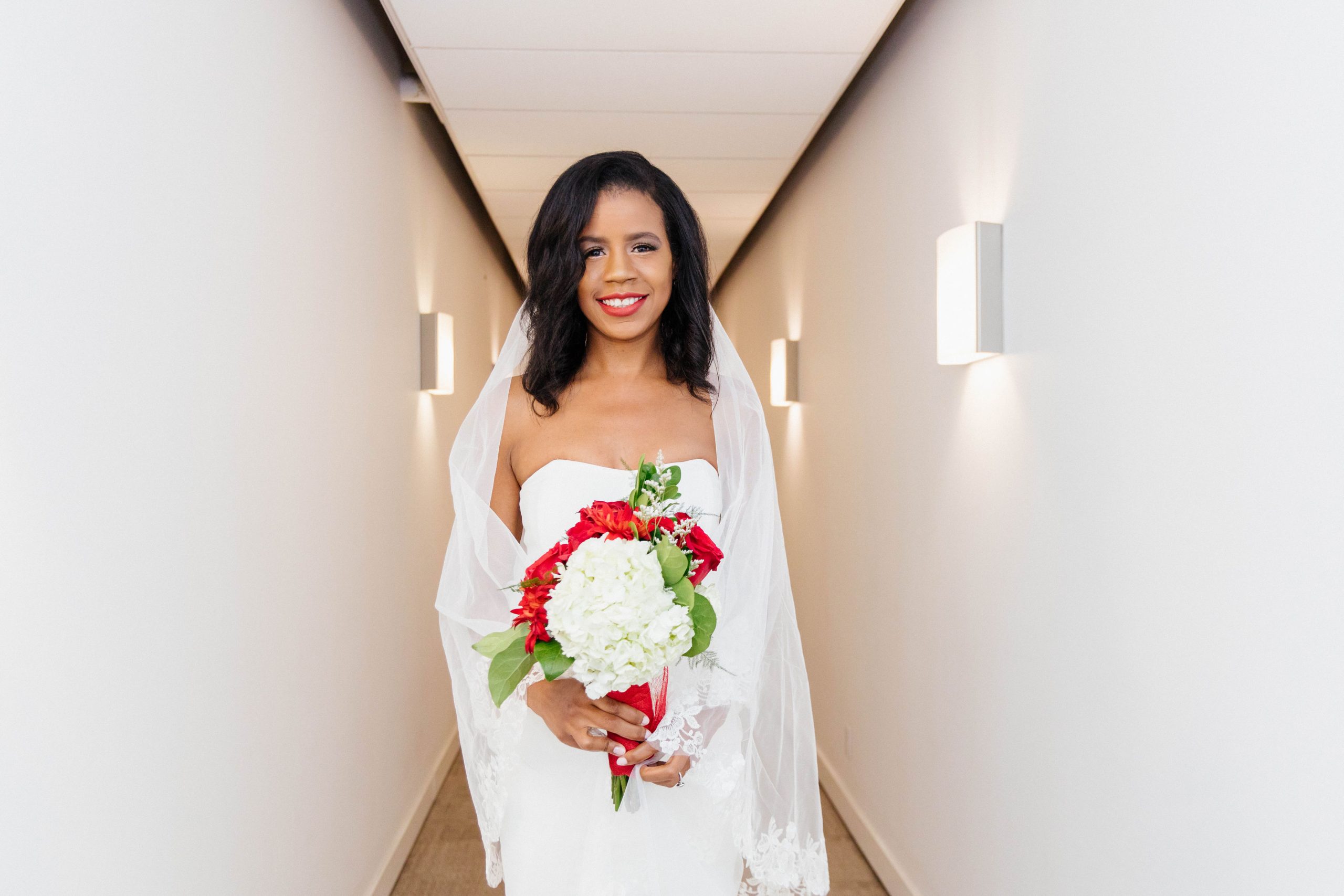 A woman in white dress holding a bouquet of flowers.