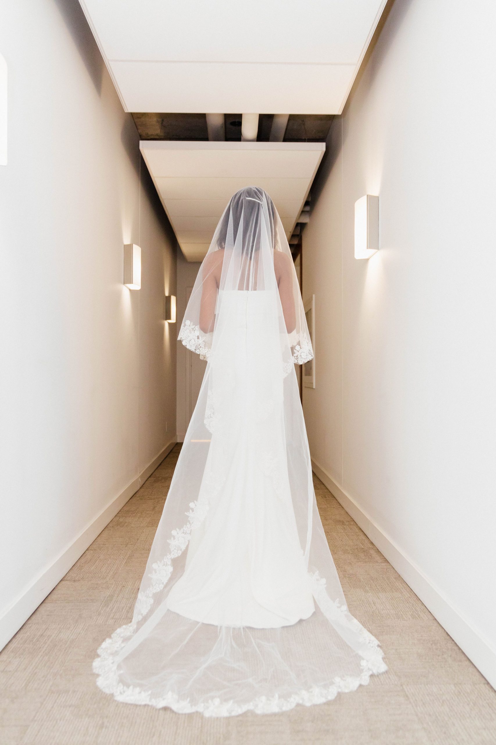 A bride in her wedding dress walking down the hall way