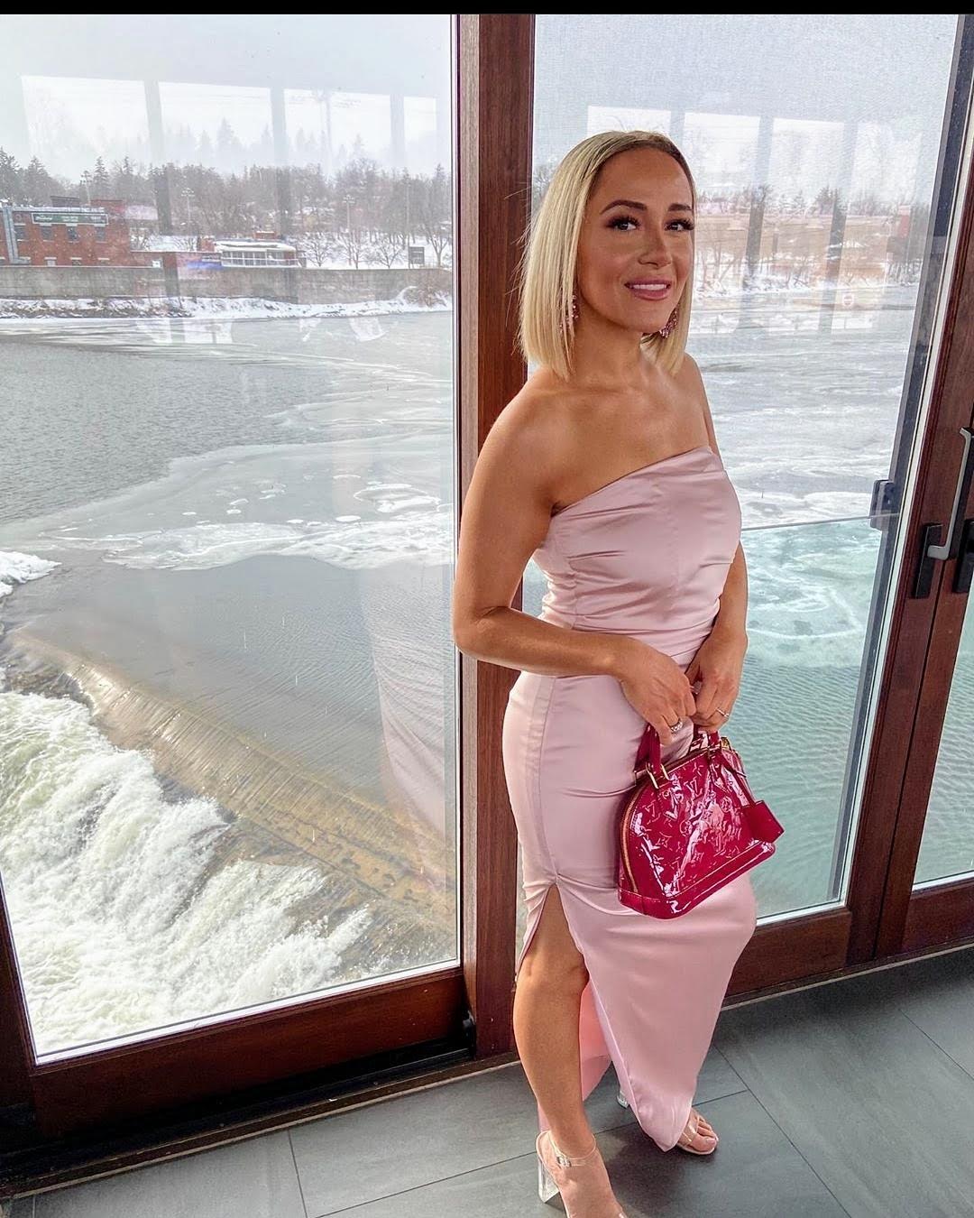 A woman in pink dress holding onto a purse