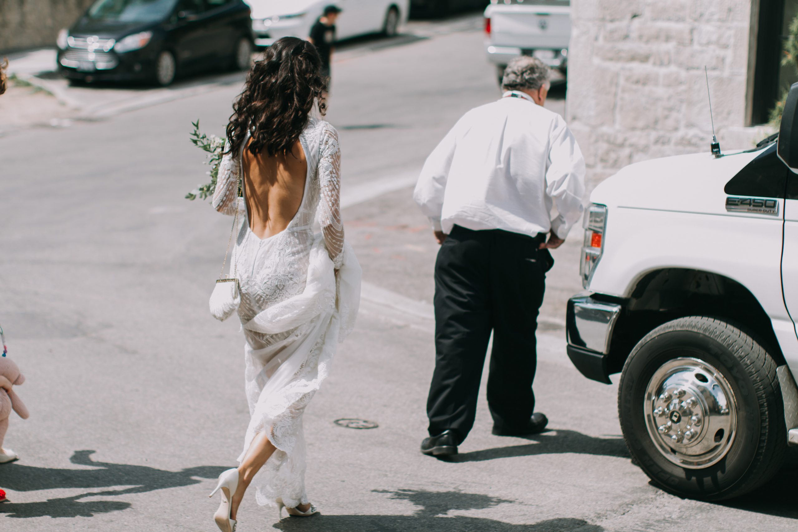 A woman in white dress walking down the street.